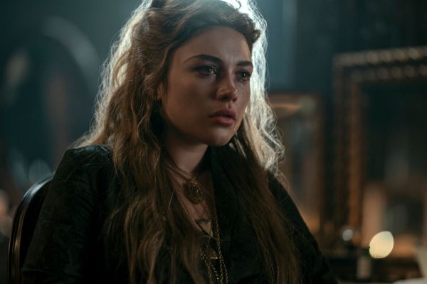 Florence Pugh as Cathy Ames in episode 107 of East of Eden sitting with her hair down and tears in her eyes.